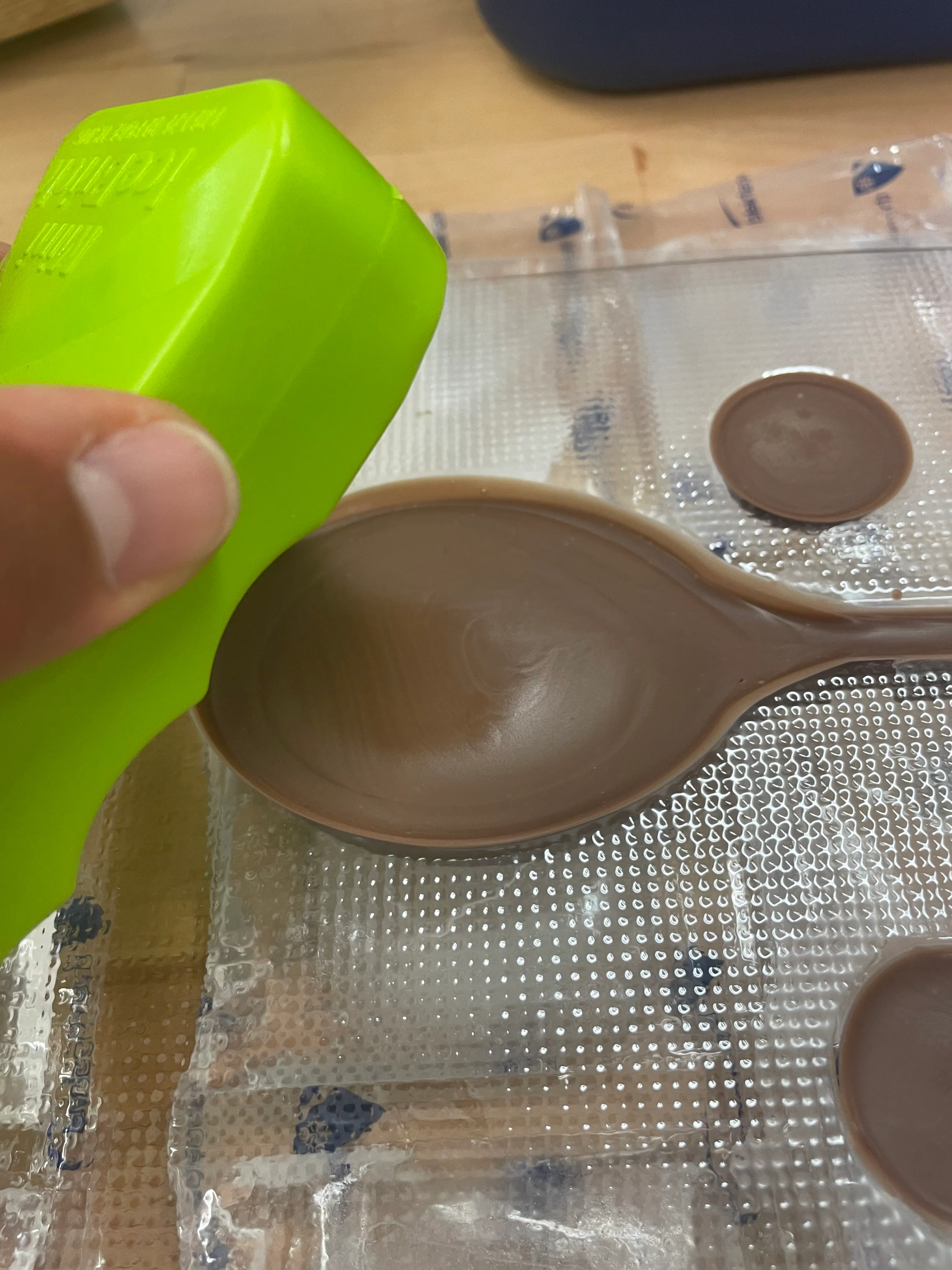 Tempered chocolate poured into the plastic mould, an ice pack pressed against the back to set the cast.